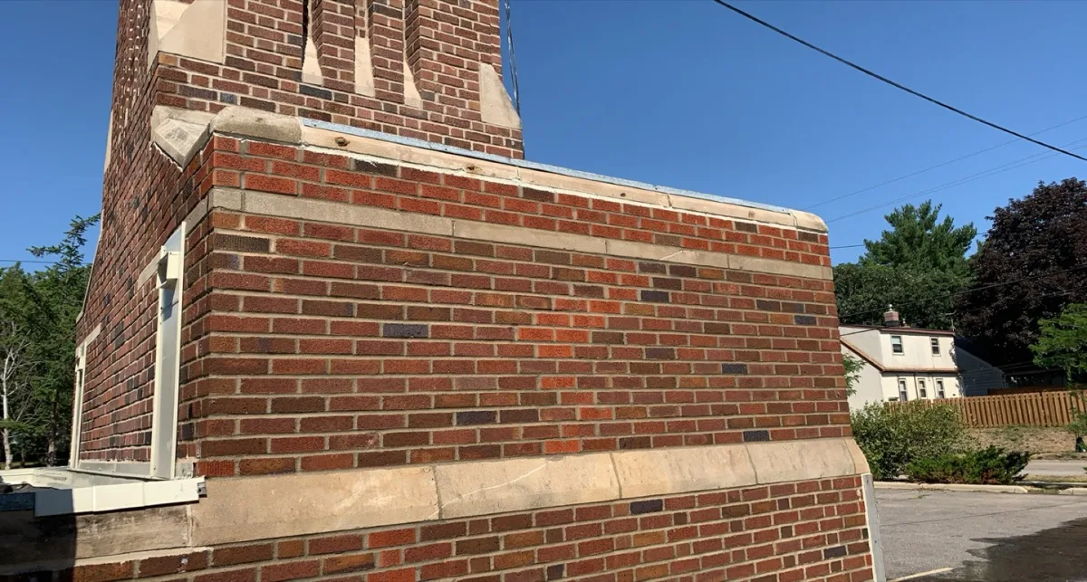 Restored brick parapet with stone banding on a church