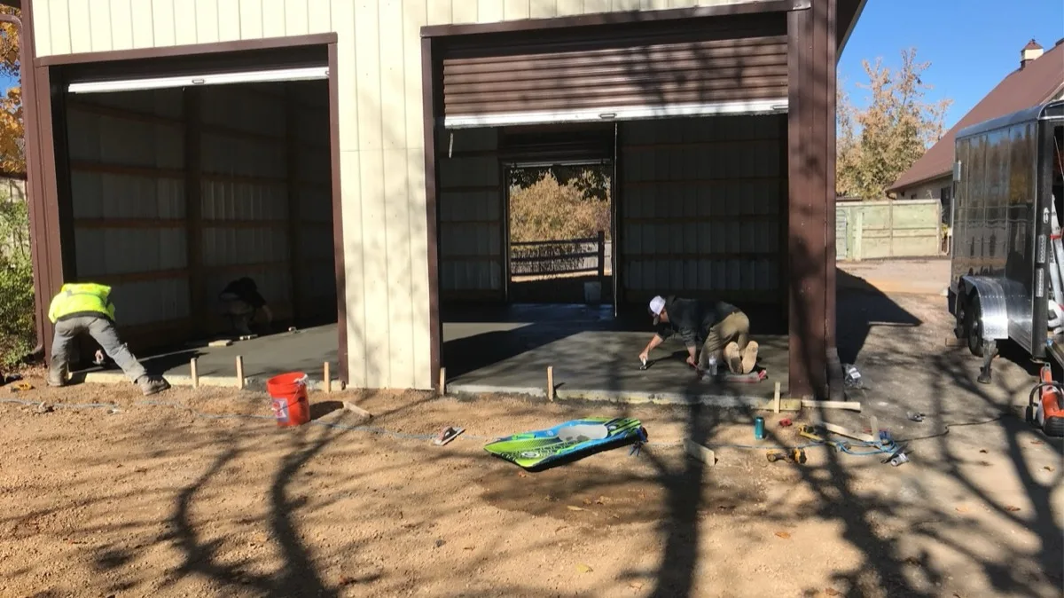 Crew finishing fresh concrete garage slabs